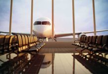 Airplane seen through terminal windows with empty gate seating