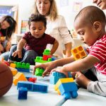 City Babysits Kids For One Night Only Karyn Polito with toddlers building blocks on a play mat