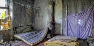 Abandoned room with torn mattresses and a rusty stove