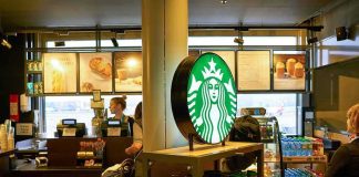 Starbucks counter with illuminated logo and customers