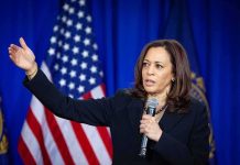 Kamala Harris speaking with microphone and gesturing on stage