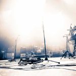 Radios Banish Singer After Gaza Controversy Empty concert stage with instruments and bright lights