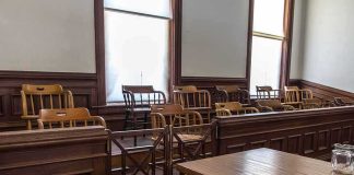Juror Kept in Safehouse- ATTACKED For Being Republican Empty jury box in a courtroom with wooden chairs