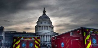 Ambulances parked near a domed government building at dusk
