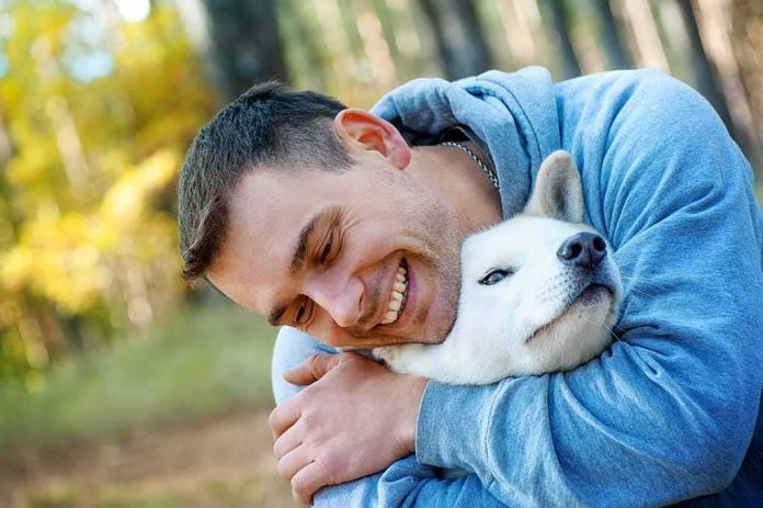 shutterstock_1507564370 man hugging a white dog outdoors