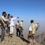 Iran Militia Strikes Tehran – Civil War Ignites Group of armed men standing on a rocky mountain ridge