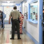 ICE Detention Death Sparks National Outrage Corrections officers escort an inmate in a jail hallway