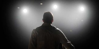 Speaker on stage under bright spotlights