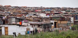 Informal settlement of corrugated metal shacks with laundry hanging
