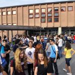 DOJ Slams University For Blatant Racial Bias Students gathered outside a school building entrance