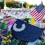 Memorial site with flowers and a U.S. flag