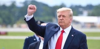 man in suit raising a clenched fist outdoors