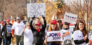 Group of protesters marching with political signs and hats