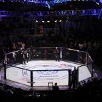 MMA octagon in arena under blue lights