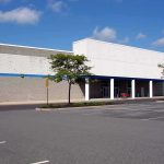 Empty retail store with blank facade and vacant parking lot