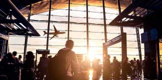 FAA Blackout Grounds ALL North Eastern Flights Airport terminal crowd at sunset with airplane silhouette outside