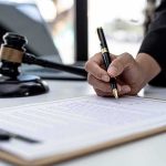 Lindsay Clancy Judge Directs Jury To Do THIS Hand signing legal document beside gavel and laptop