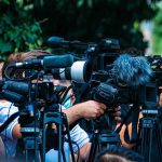 Nepotism Storm Hits Tight Senate Race TV news cameras crowding together at an outdoor event