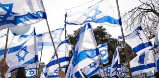 Crowd waving Israeli flags outdoors