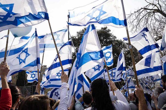 shutterstock_2264581927 Crowd waving Israeli flags outdoors