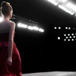 Miss Carolina STRIPPED Of Title After THIS Happened! Model in a red dress walking on a runway under bright stage lights