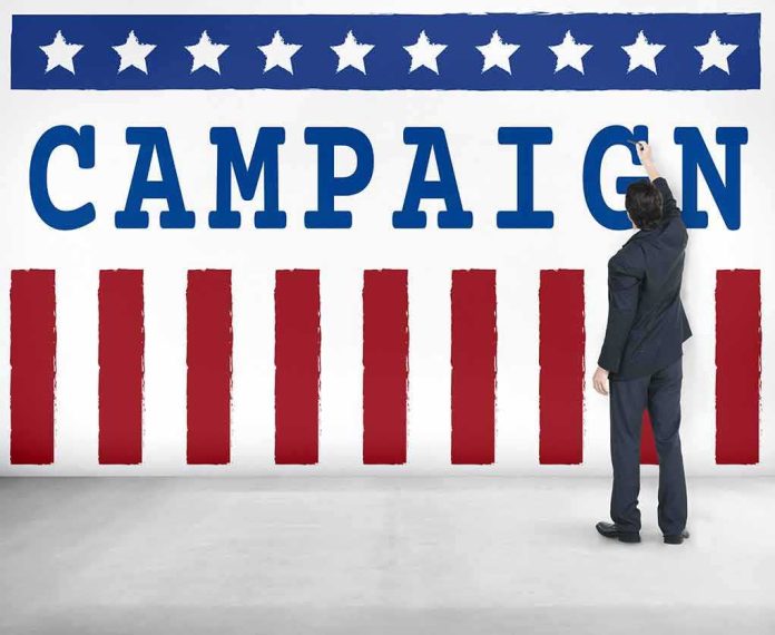 shutterstock_486646441-1 Man in suit writing on large campaign banner with stars and stripes