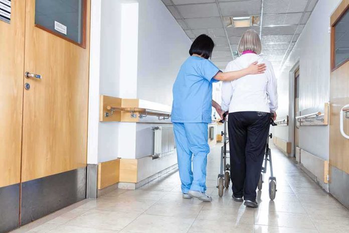 Nurse assisting an elderly person with a walker in a hallway