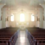 Empty church interior with sunlight at the altar