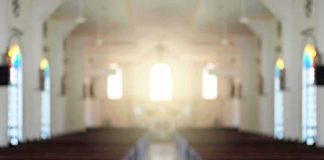 Empty church interior with sunlight at the altar