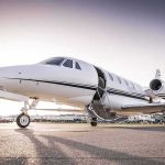 Desperate Rescue Underway After Jet Crashes Onto Highway! Private jet on airport tarmac with open door at sunset