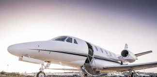 Private jet on airport tarmac with open door at sunset