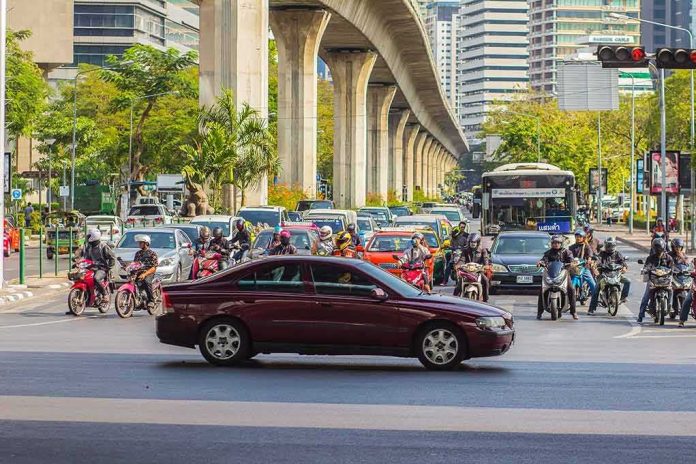 Urban traffic at intersection with motorbikes and car