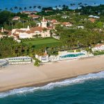 Aerial view of a beachfront estate with pool and palm trees