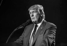 Donald Trump speaking at a microphone in a black-and-white photo