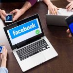 Man Who Mocked Kirk’s Death Wins MASSIVE $850K Case Laptop with Facebook on screen surrounded by smartphones