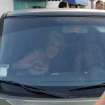 Britney Spears gestures from inside a car behind the windshield