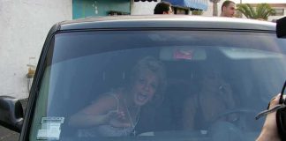 Britney Spears gestures from inside a car behind the windshield
