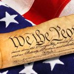 Body Armor Ban Ruled Unconstitutional in Major 2A Win Rolled U.S. Constitution on an American flag
