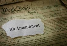 Fourth Amendment text on torn paper over the U.S. Constitution