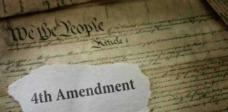 Fourth Amendment text on torn paper over the U.S. Constitution