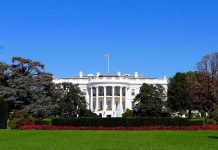 The White House facade with flag and gardens