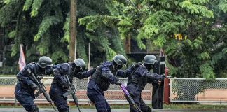 Police tactical team advancing in rain