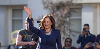 woman in navy suit waving at an outdoor event