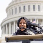 What Ilhan Omar Ordered Staffers To Do Is DAMNING! Woman in hijab speaking at podium with microphones