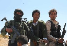 Three armed men standing outdoors