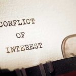 Typewriter typing the words conflict of interest