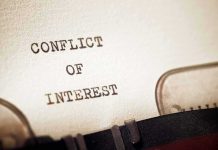 Typewriter typing the words conflict of interest