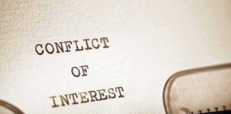 Typewriter typing the words conflict of interest