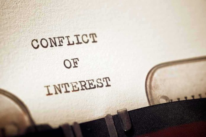 shutterstock_1915121200 Typewriter typing the words conflict of interest