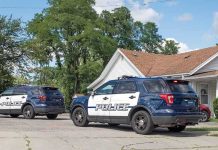 Two police SUVs parked near a suburban house